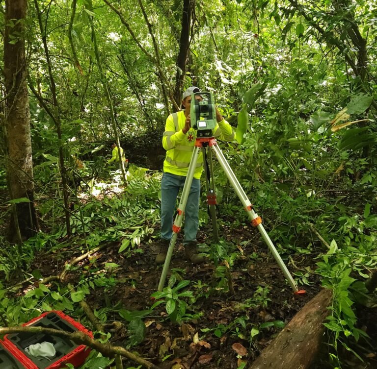 Topógrafo realizando medición de terreno con estación total