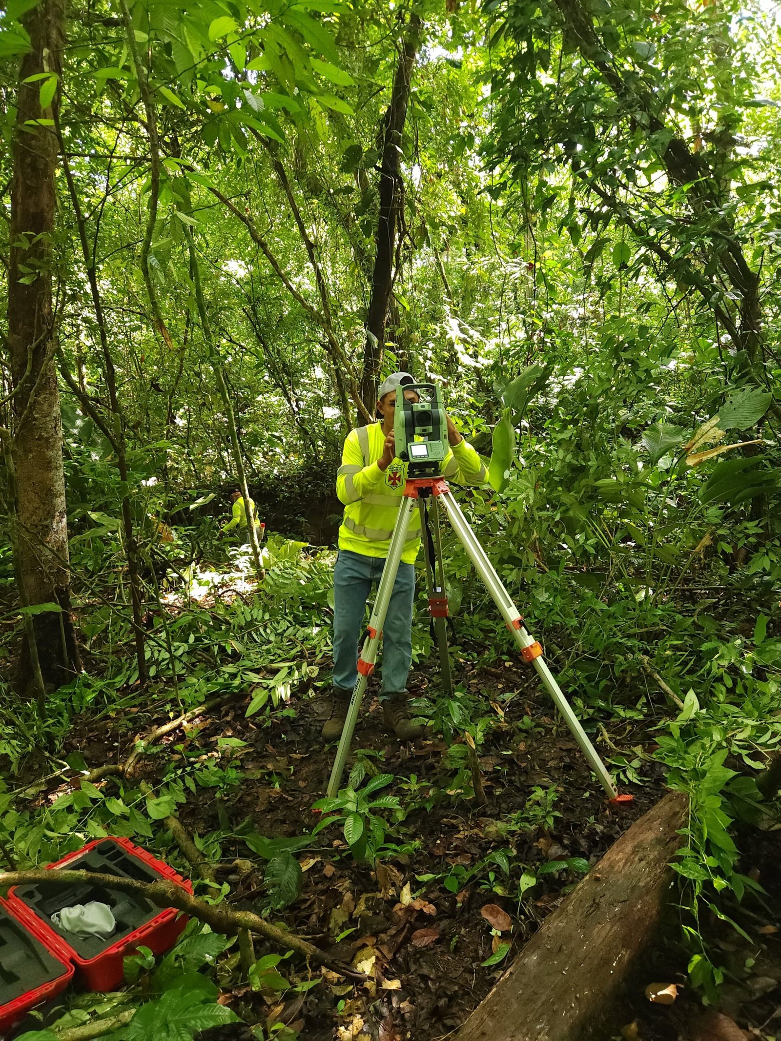 Topógrafo realizando medición de terreno con estación total